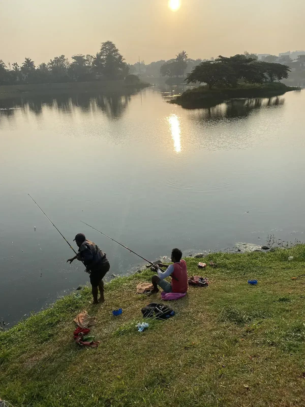 Pescador de pie al amanecer en un entorno urbano junto al agua